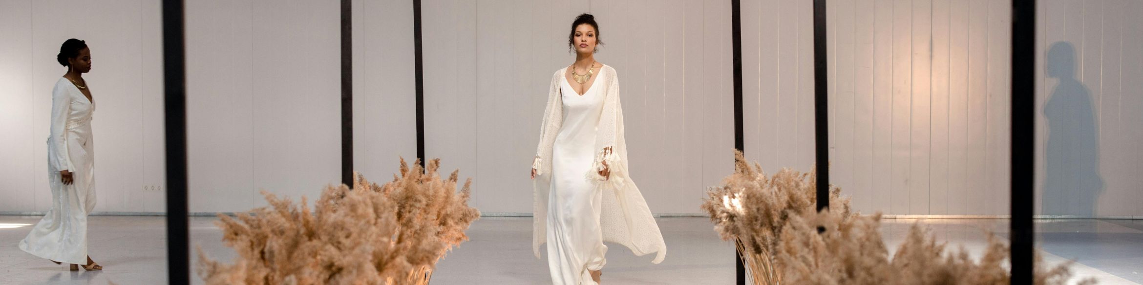 Una donna cammina lungo una passerella. L'immagine viene utilizzata come immagine di intestazione per promuovere le tendenze della moda.