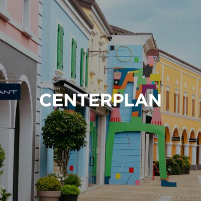 L'immagine mostra una parte dell'area interna del Palmanova Designer Village.Sopra di essa è posizionato il testo Mappa del centro in tedesco.