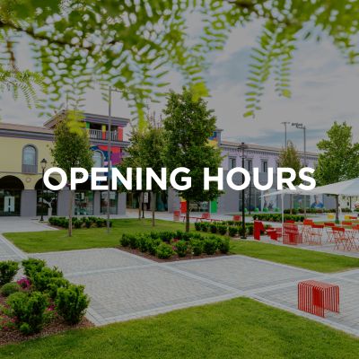 Viene mostrata l'entrata del Palmanova Designer Village. L'immagine riporta inoltre il titolo “Orari di apertura”